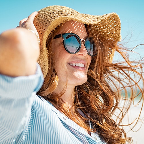 Adult wearing a hat and sunglasses