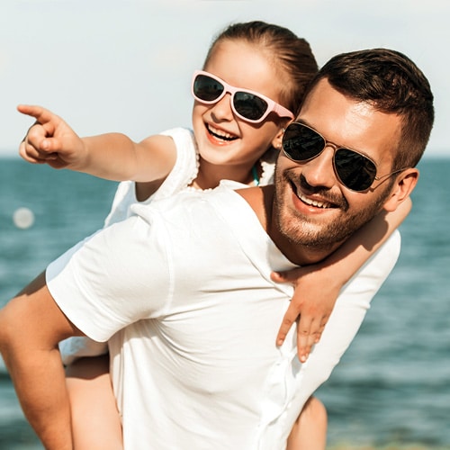 Man and kid smiling to the camera and being outdoors
