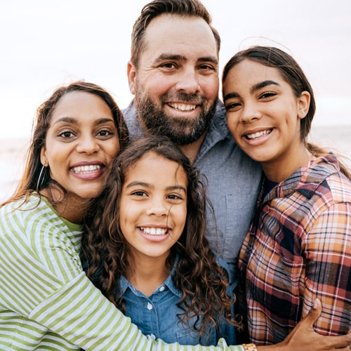 Family hugging and smiling to the camera