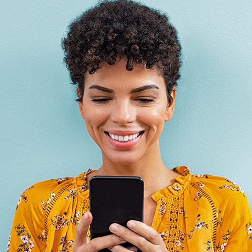 A woman smiling with her phone in hand